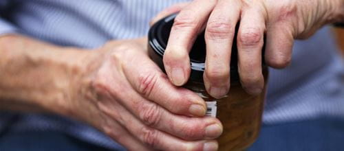 An older man attempting to open a jar