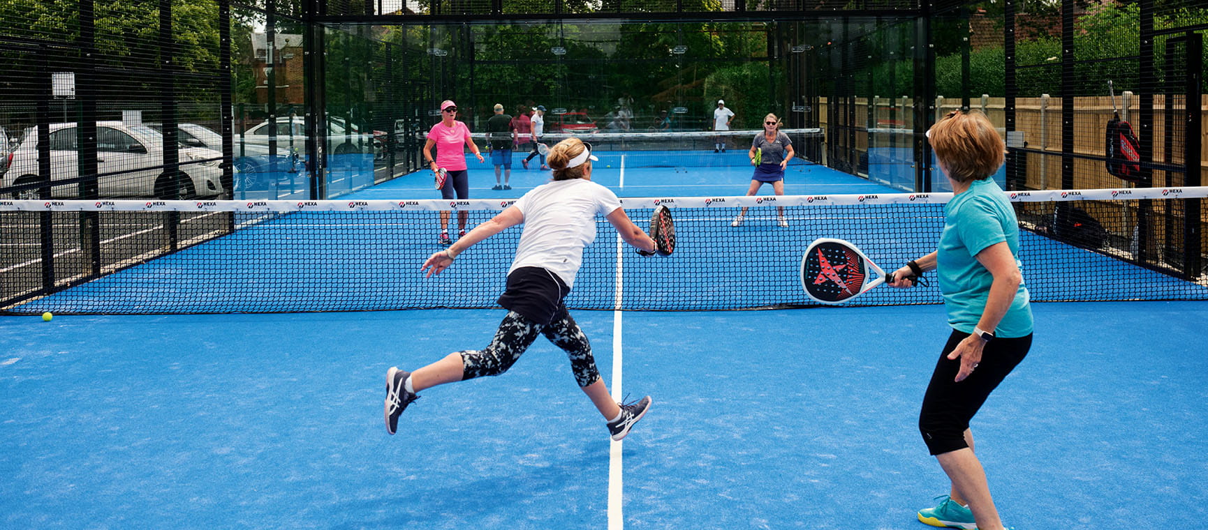 Four older people engaged in a game of Padel
