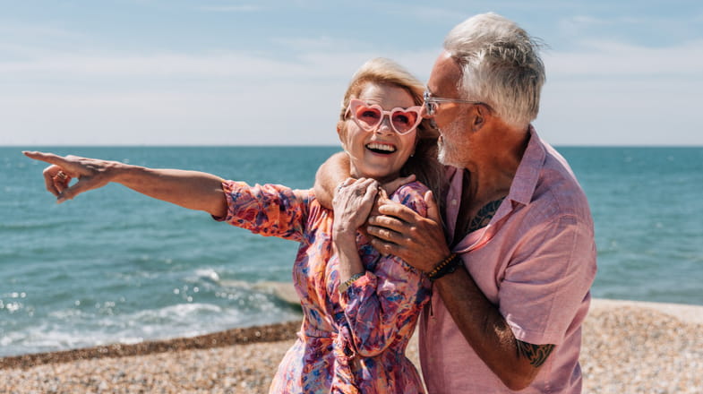 A happy man and woman on a beach in the sunshine