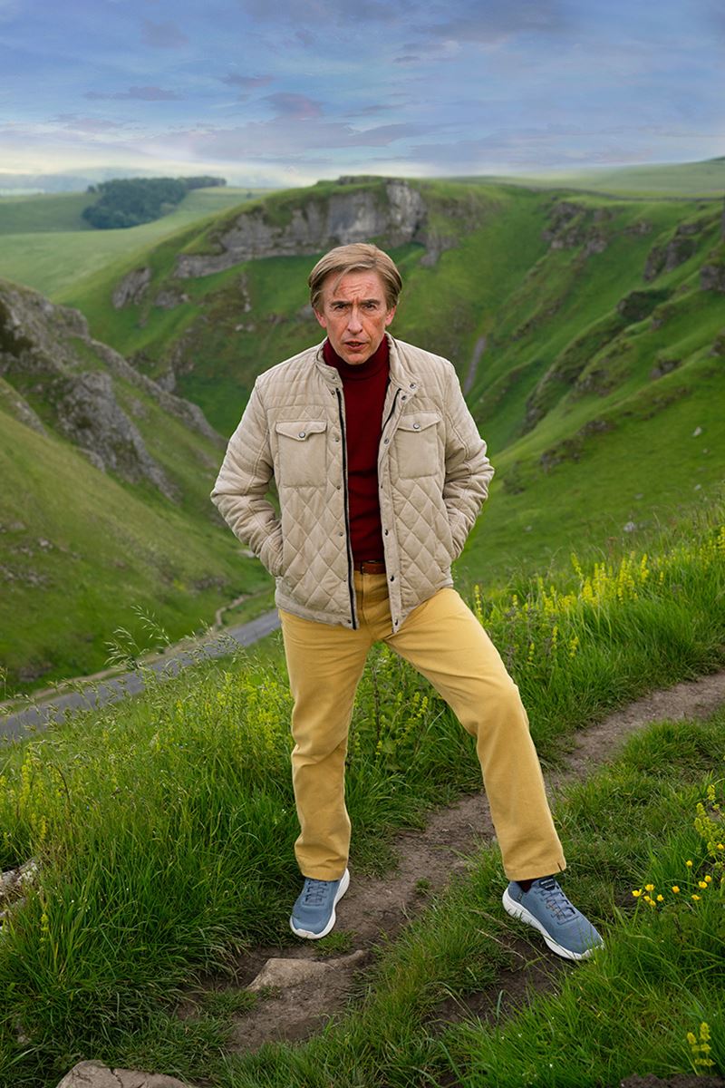 Alan Partridge standing on a hill