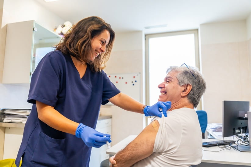 Smiling nurse giving a vaccination to a patient