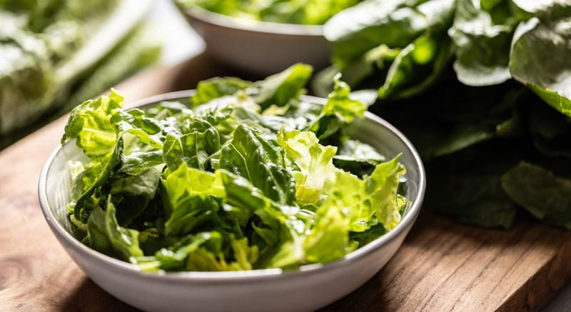 A bowl of green vegetables on a table