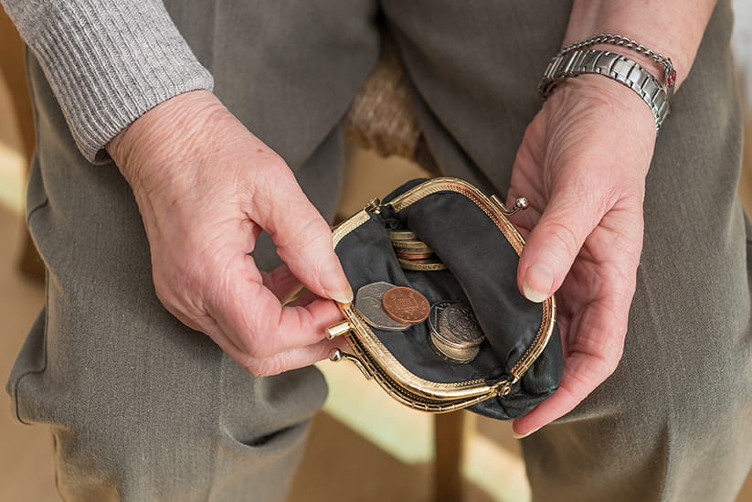 An older person counting the money in their purse