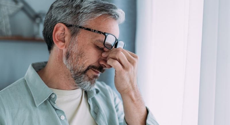 Older man with glasses feeling dizzy