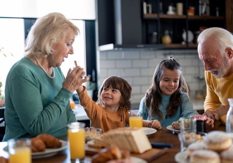 Grandparents having breakfast with their grandchildren