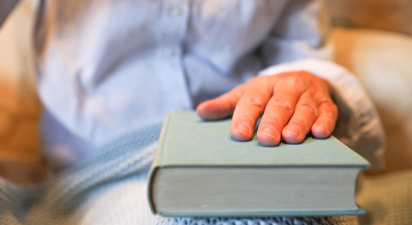 Persson with hand on closed book