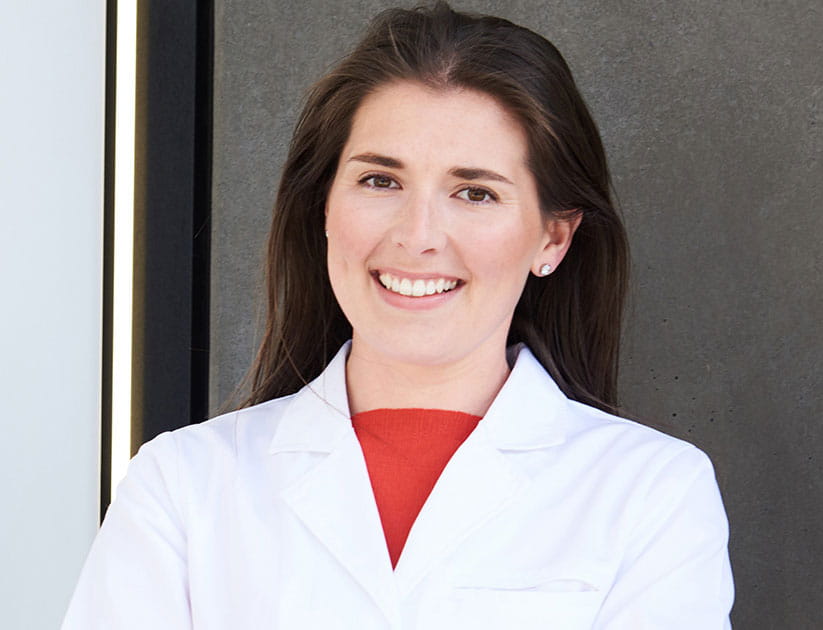 Dr Dr Nichola Conlon wearing a white coat and smiling at the camera