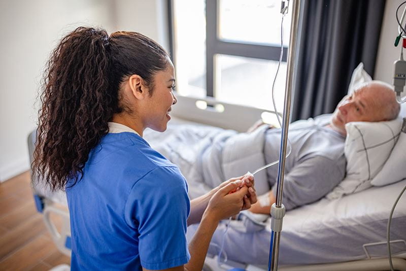 A nurse checking the IV of an older patient
