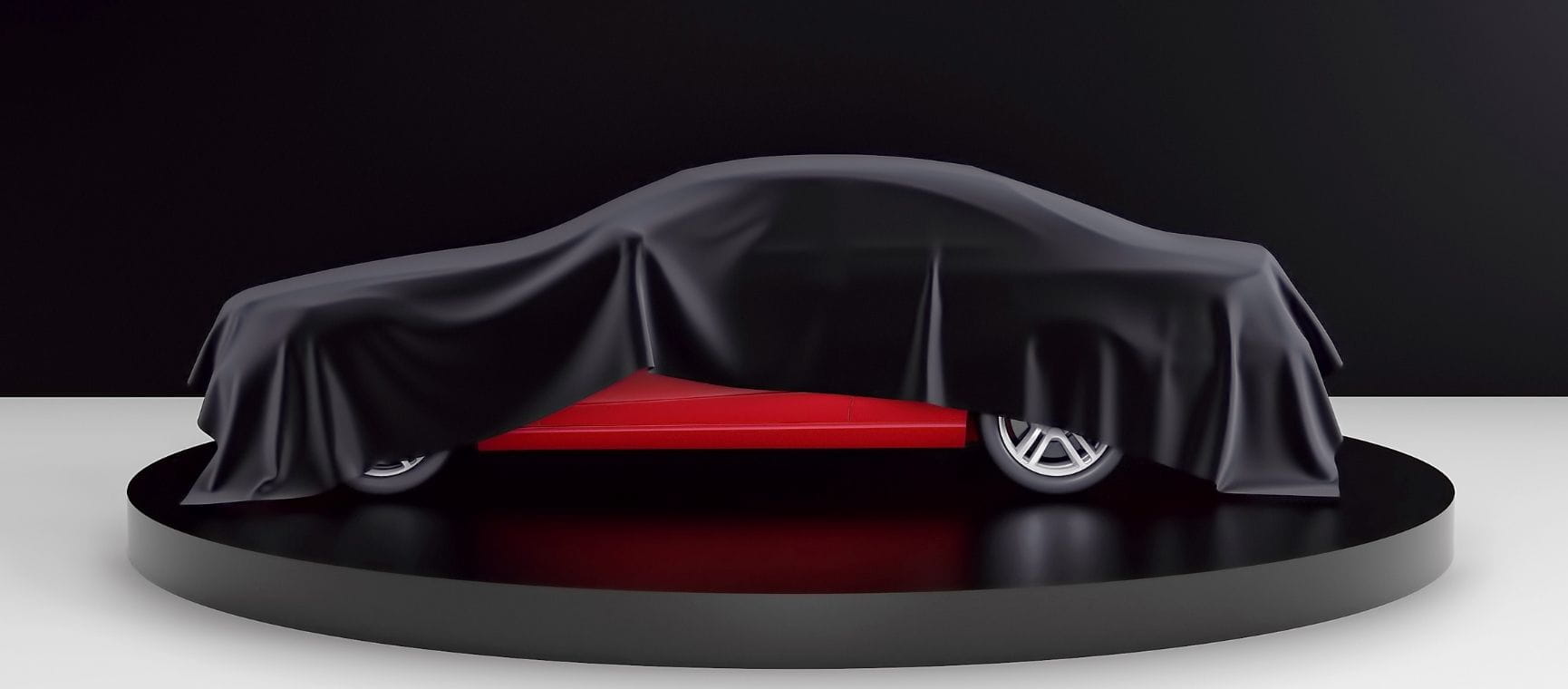 A red car almost hidden by a black cloth