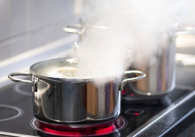 A metal pan on a hob steaming