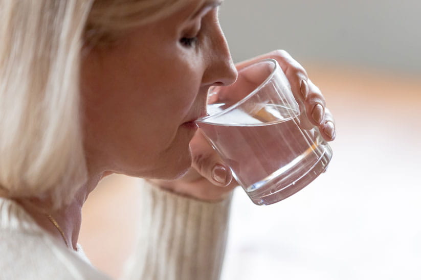 Older woman drinking a glass of water