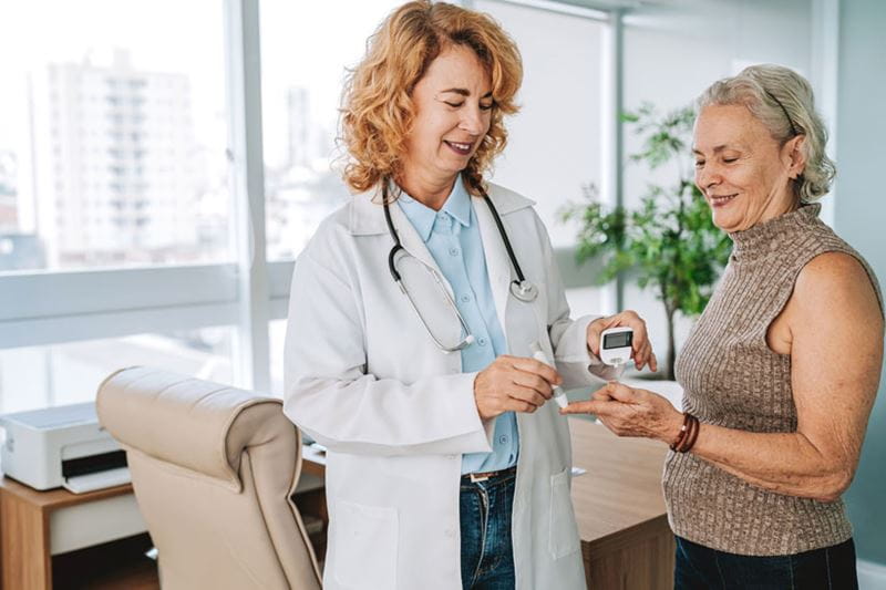 Doctor measuring senior patient's diabetes