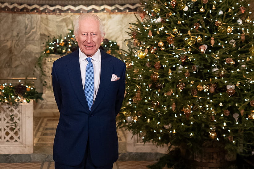 King Charles in front of a Christmas tree