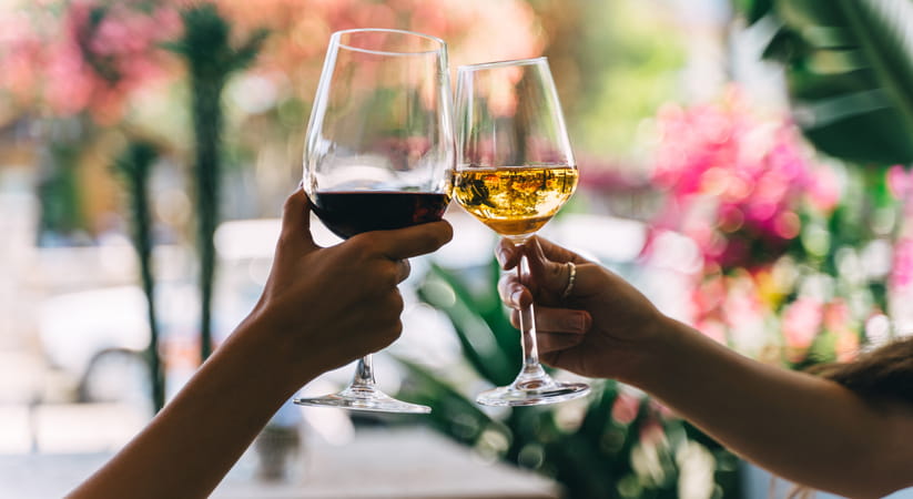 Close-up of two people clinking wine glasses