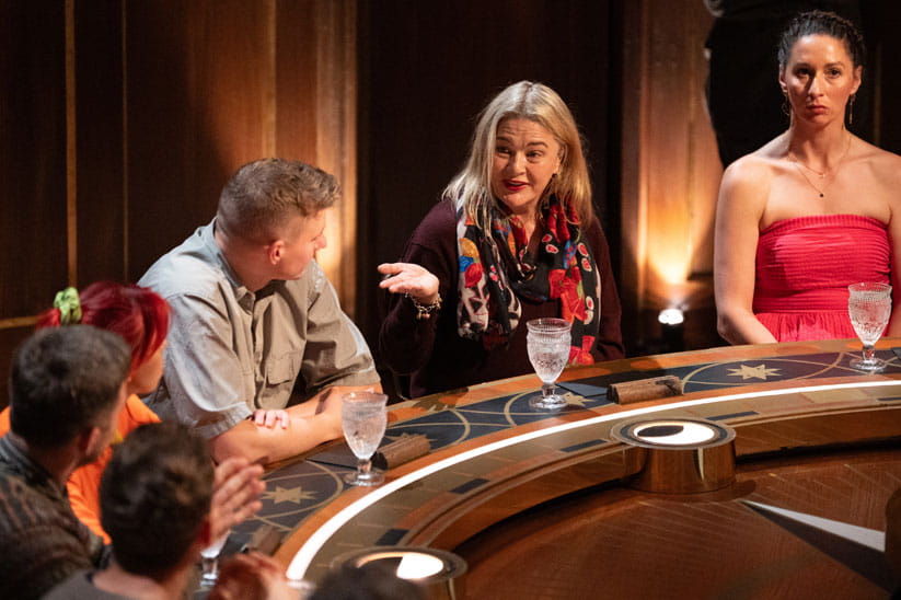 Group of people in discussion around a table, with Harriet as the main focus