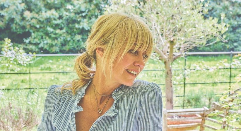 Clodagh McKenna sat outside wearing a blue open shirt