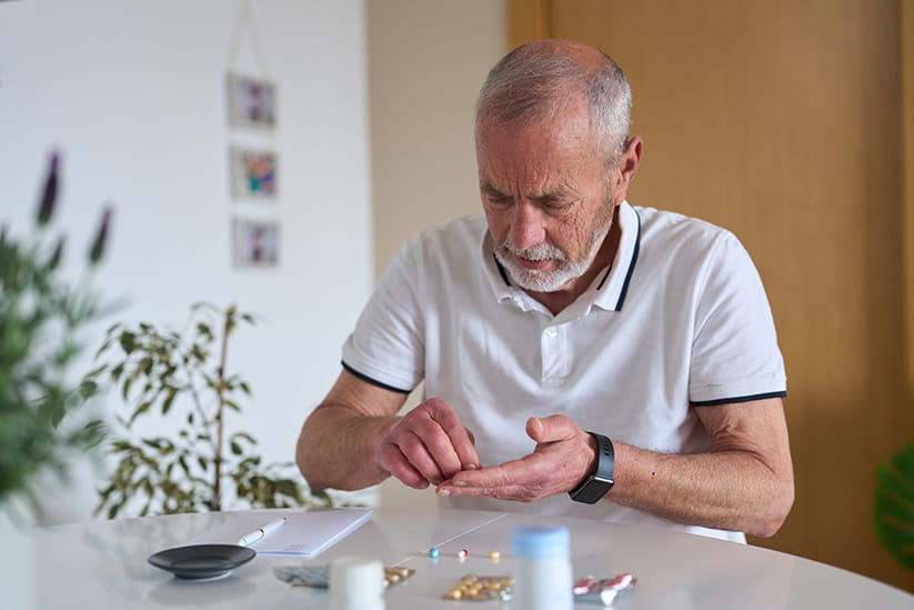 An older man trying to organise multiple medications