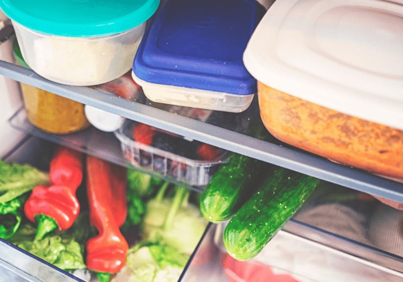 A well stocked fridge with veg and tupperware