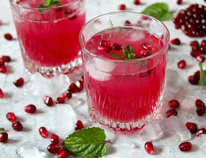 Ripe pomegranate with juice on light background