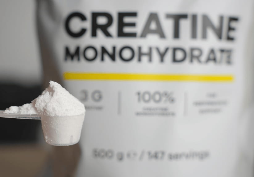 A packet of creatine with a scoop of the powder