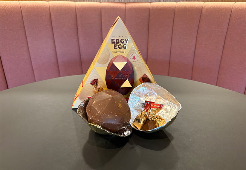 The angular Toblerone easter egg in front of its triangular packaging