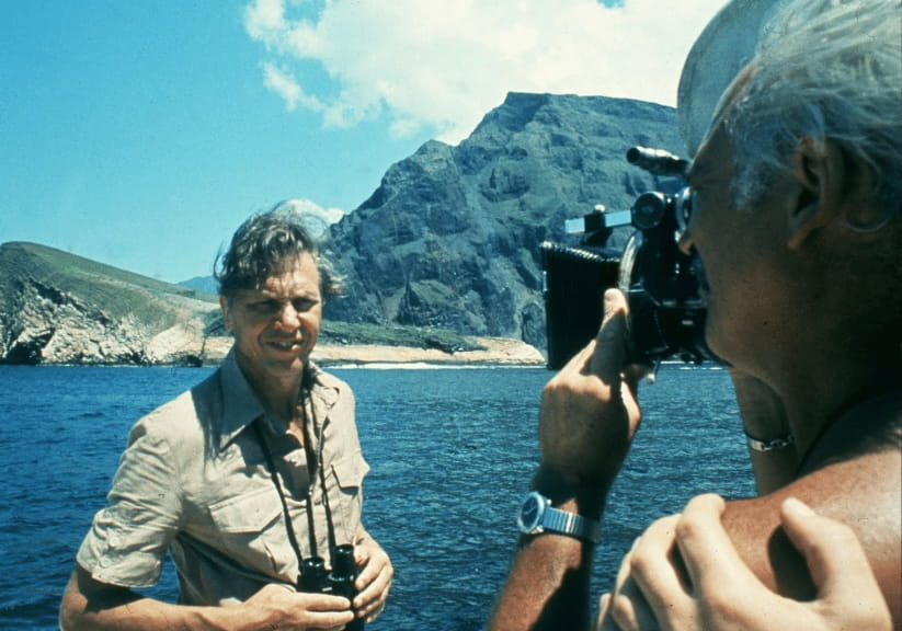A young Attenborough being filmed on a boat