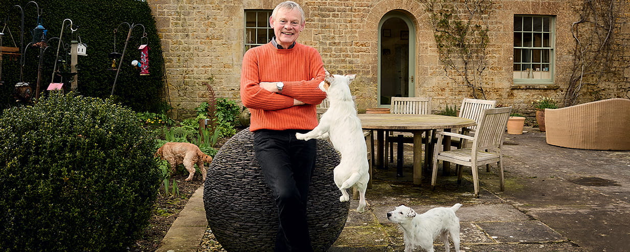 Martin Clunes in his garden with his dogs