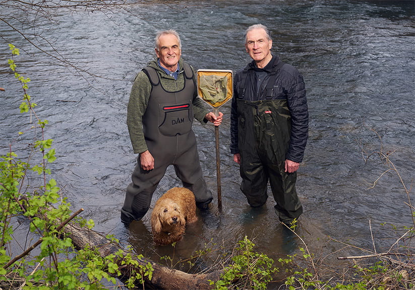 Ash, Peter and Archie the dog standing in the river