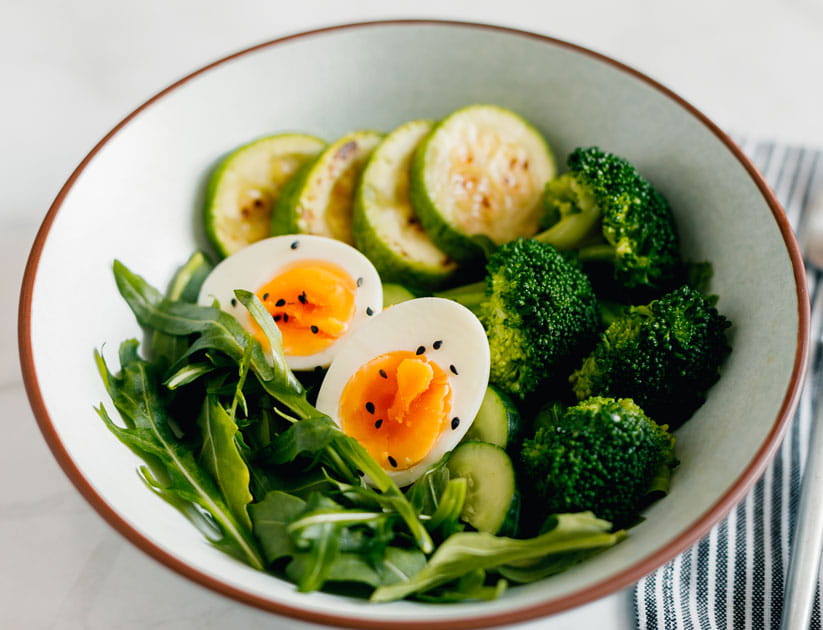 Healthy green vegetable buddha bowl with a boiled egg on top
