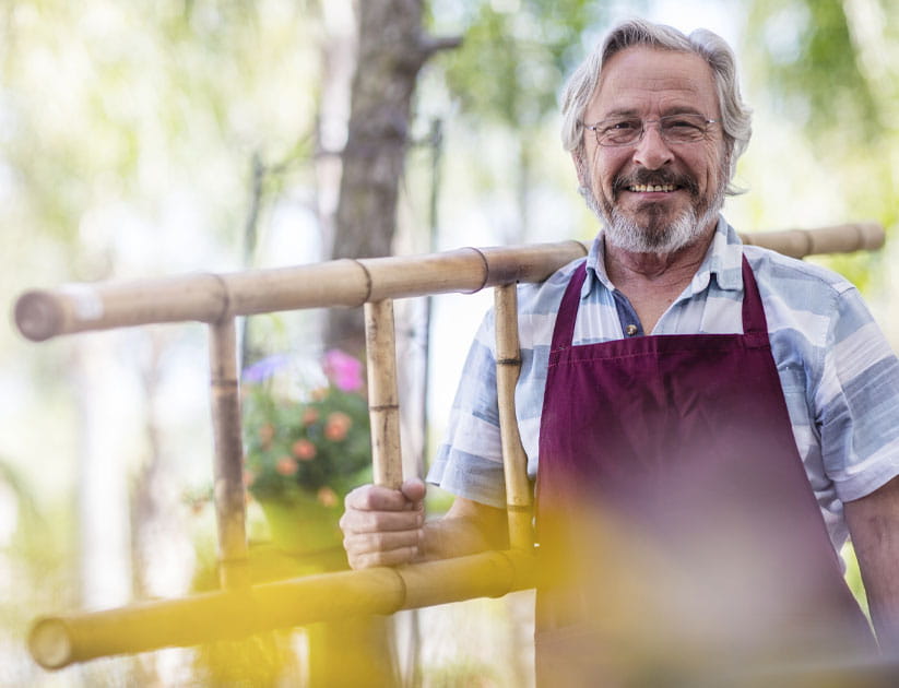 Mature man carrying a bamboo ladder