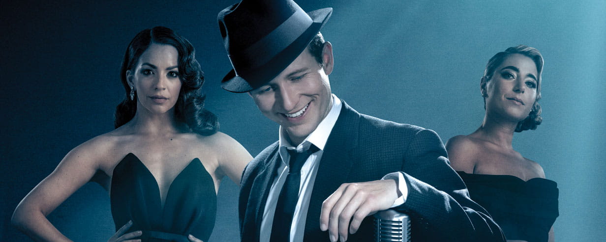 Three of the cast from the Sinatra musical, with Joel Harper-Jackson as Sinatra wearing his iconic hat standing in front of a mic