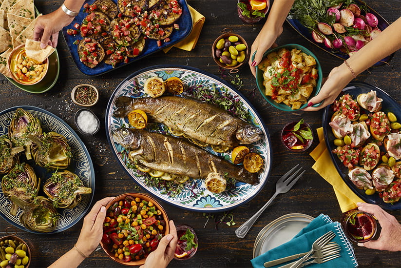 Mediterranean dishes and appetizers being enjoyed by several people