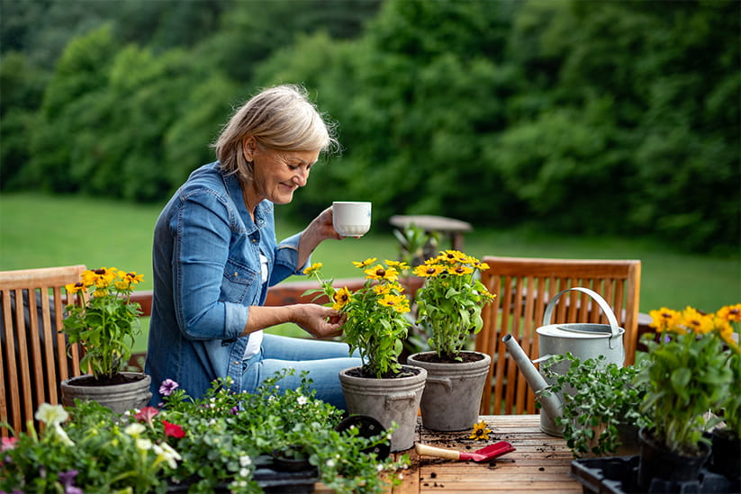 Older woman taking care of flowers in garden