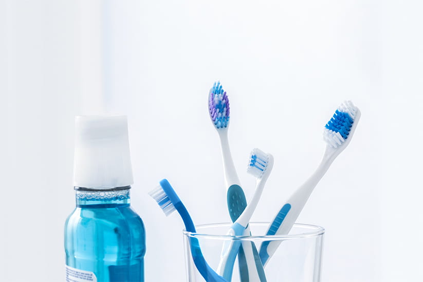 Toothbrushes in glass next to mouthwash bottle