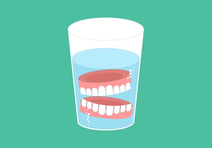 An illustration of dentures soaking in a glass