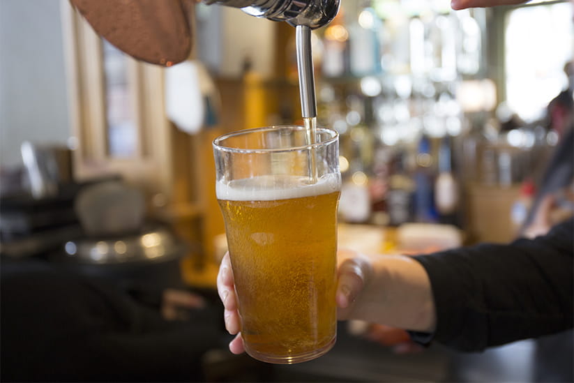 A close-up of a beer being poured in a pub