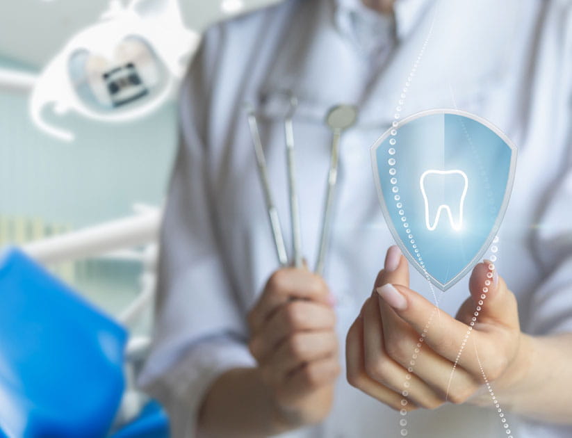 A person in a white medical coat holding a stylised shield with a tooth on it in one and dental tools in the other