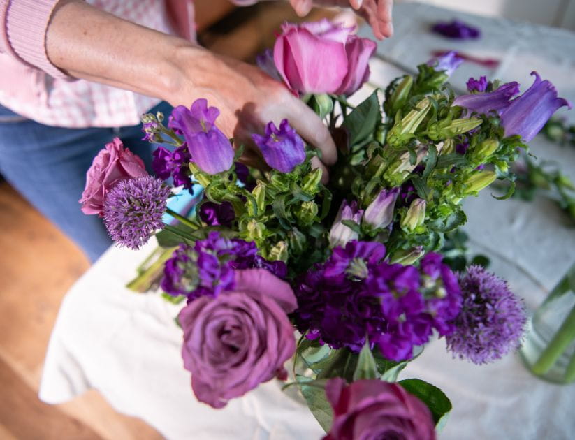 Purple alliums with roses in a flower arrangement