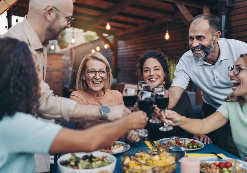 Six friends toast wine at a dinner party