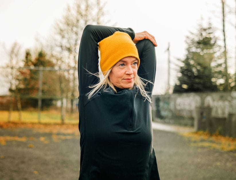 A woman stretches outside