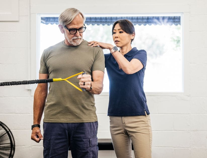 A physiotherapist helping a man with exercises