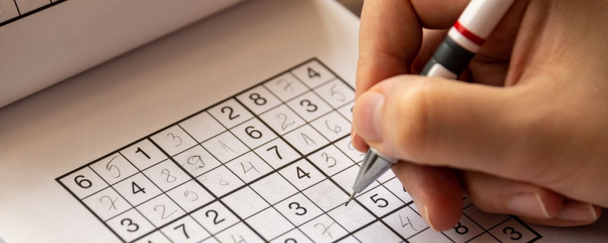 Person solving a sudoku puzzle