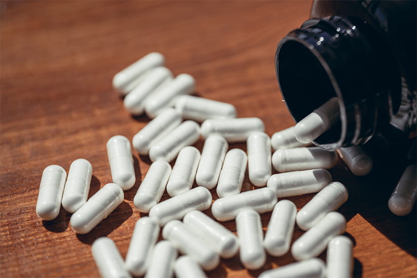 Vegetable capsules with white medicine inside.
