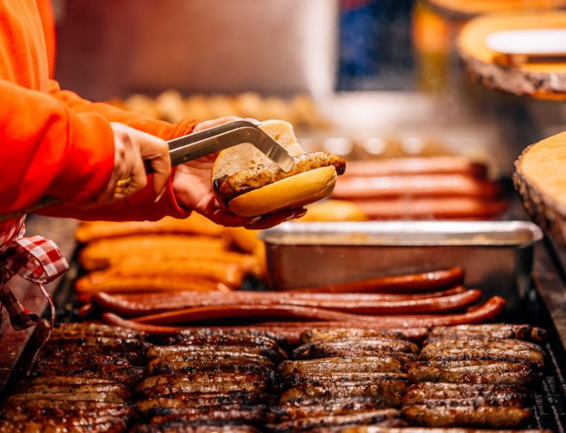 market vendor cooking sausages at the market in nuremberg