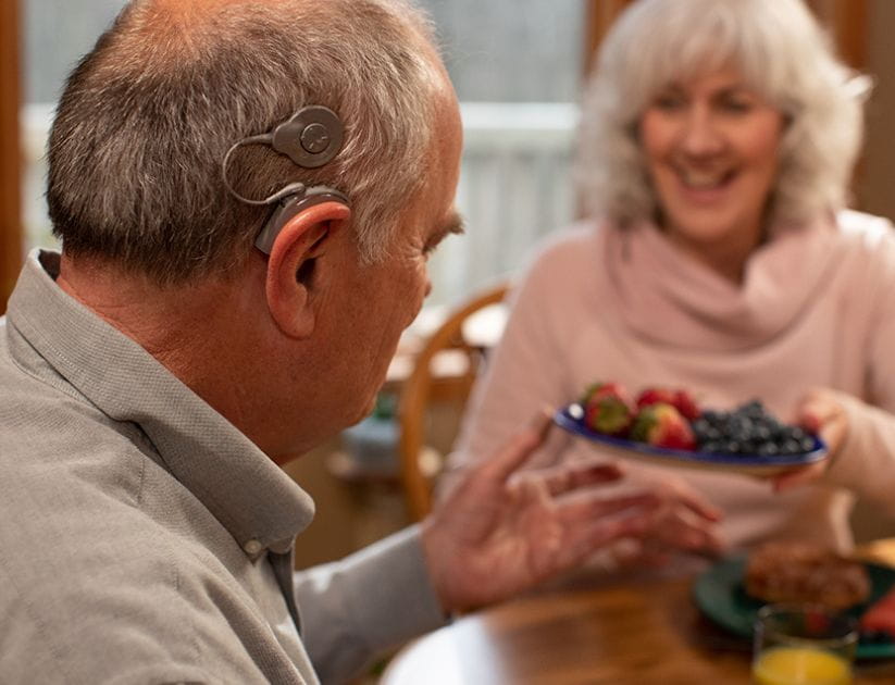 A man with the cochlear implant making use of it