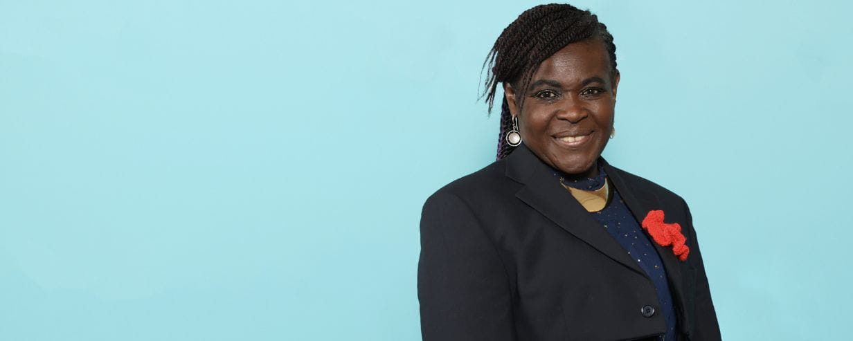 Dame Dr Maggie Aderin portrait with a blue background