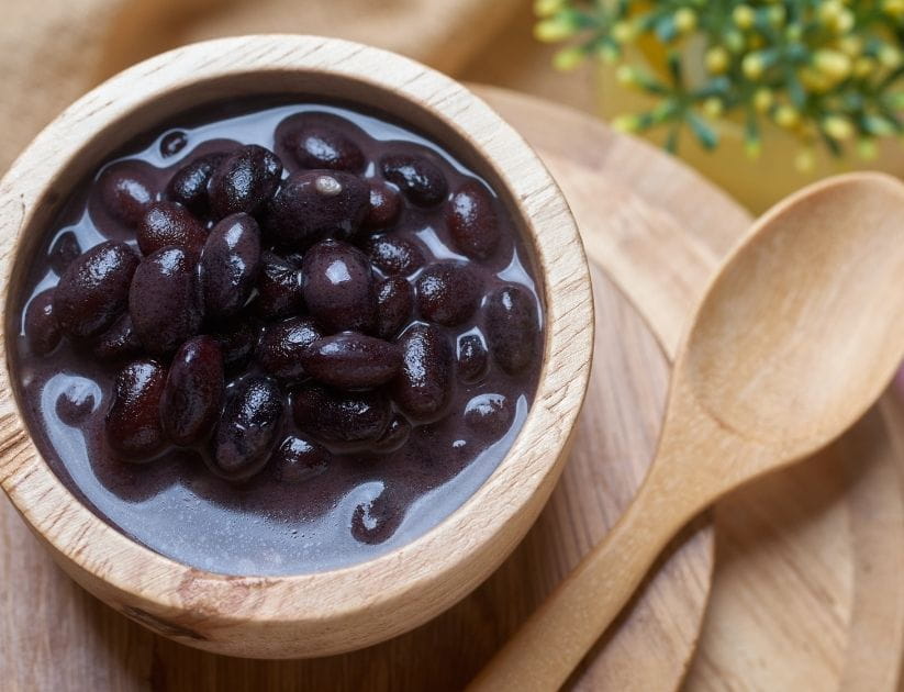 Black bean in coconut milk soup served on a wooden bowl