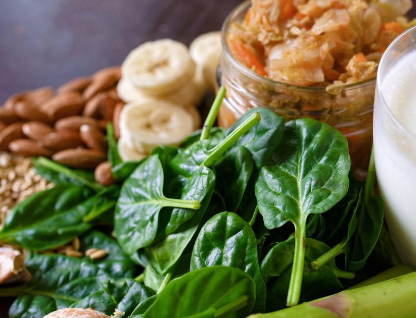 A collection of spinach, almonds, oats, and bananas that help to boost magnesium