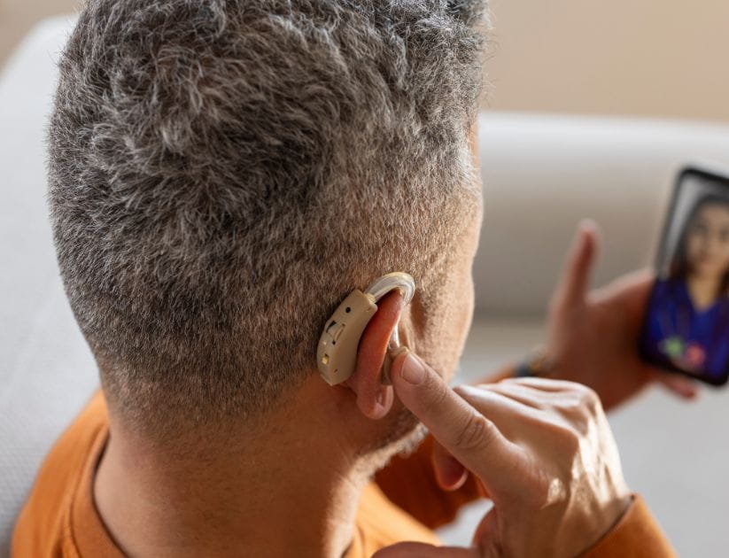 Man using a hearing aid whilst on a video call