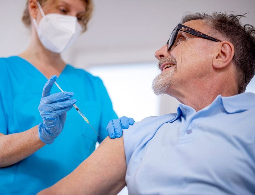 Man getting a vaccine from a female doctor